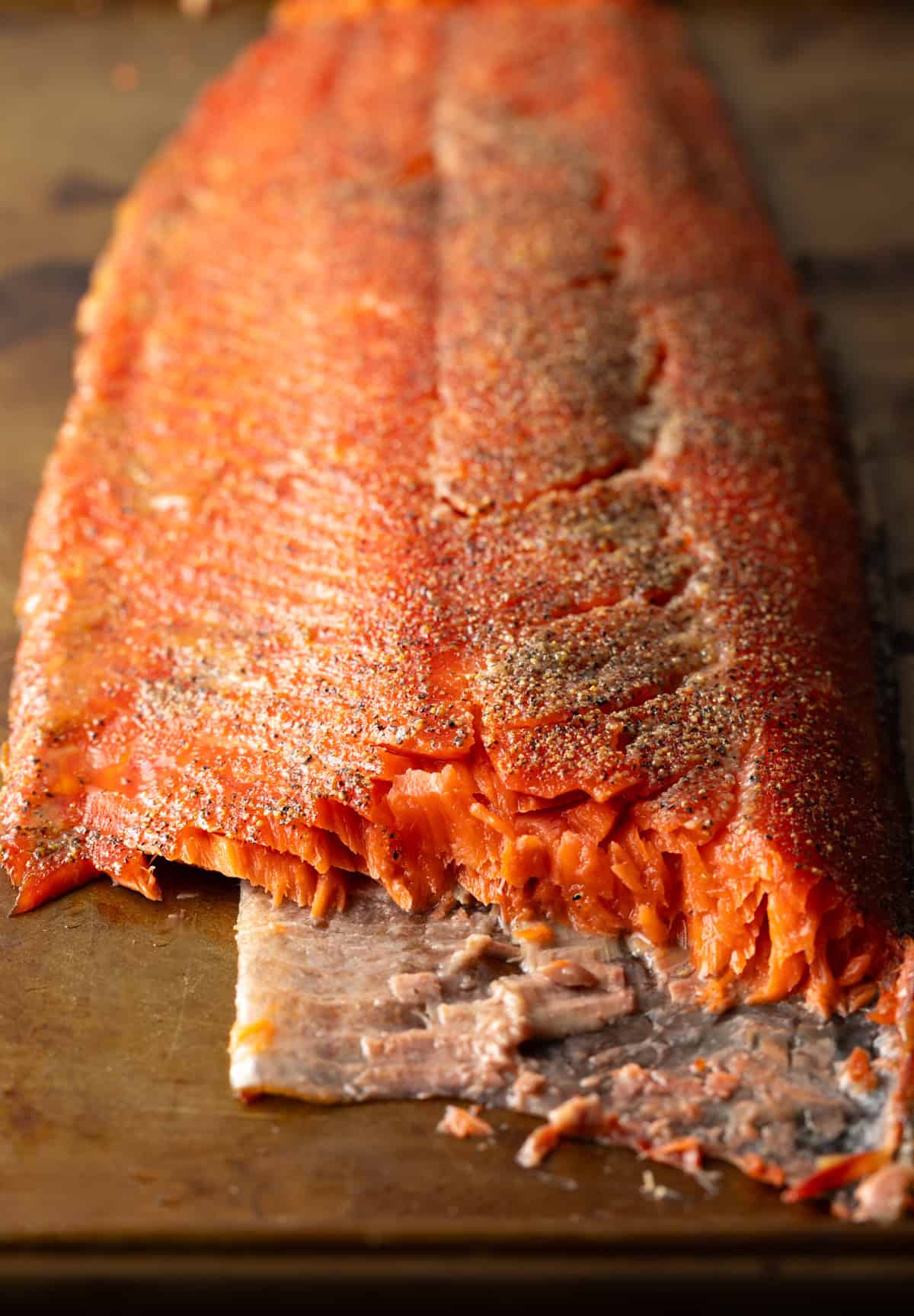 A whole fillet of cold smoked salmon, sliced horizontally to show the salmon texture after smoking.
