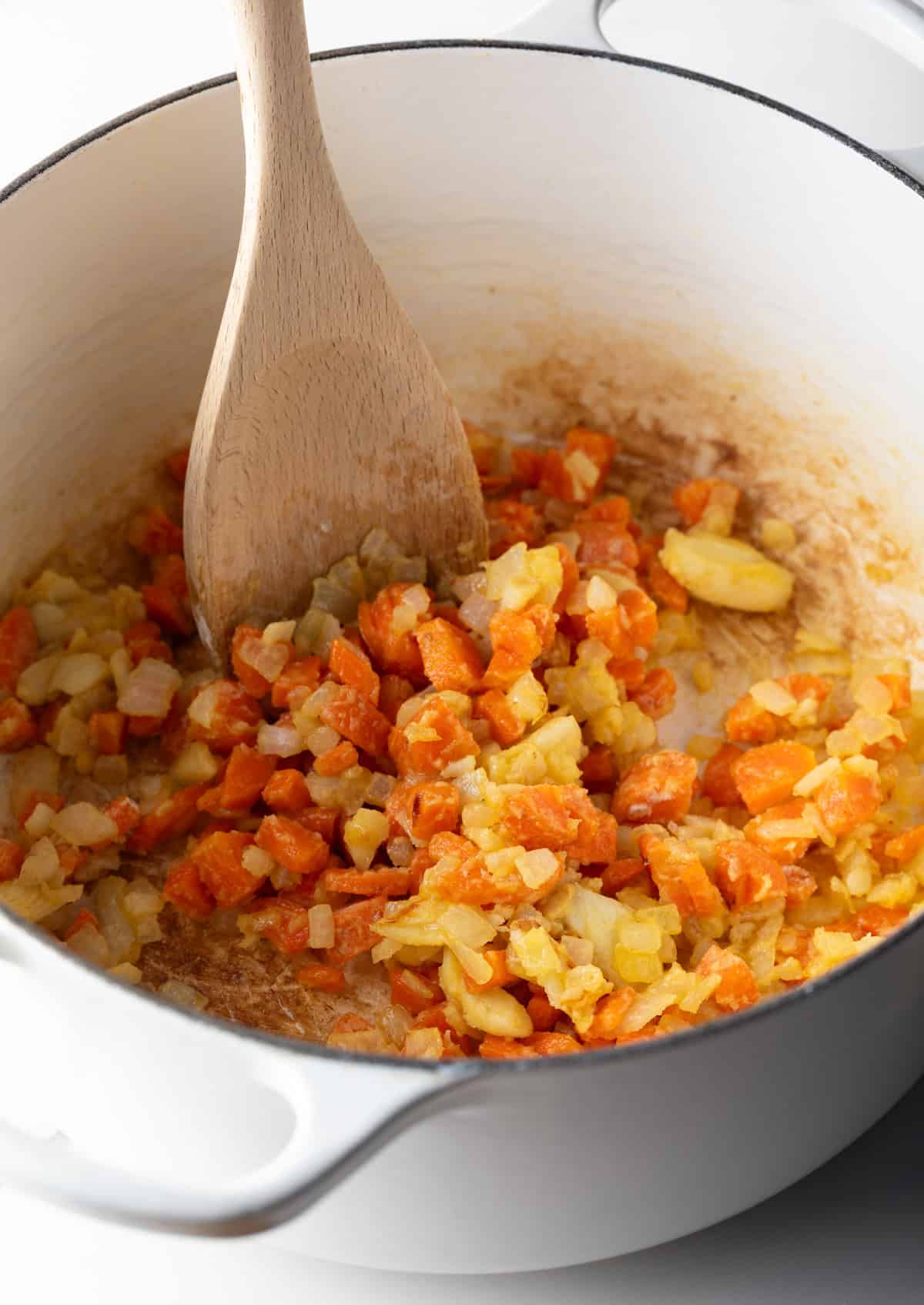 Flour is being stirred into the sautéed veggie mixture.