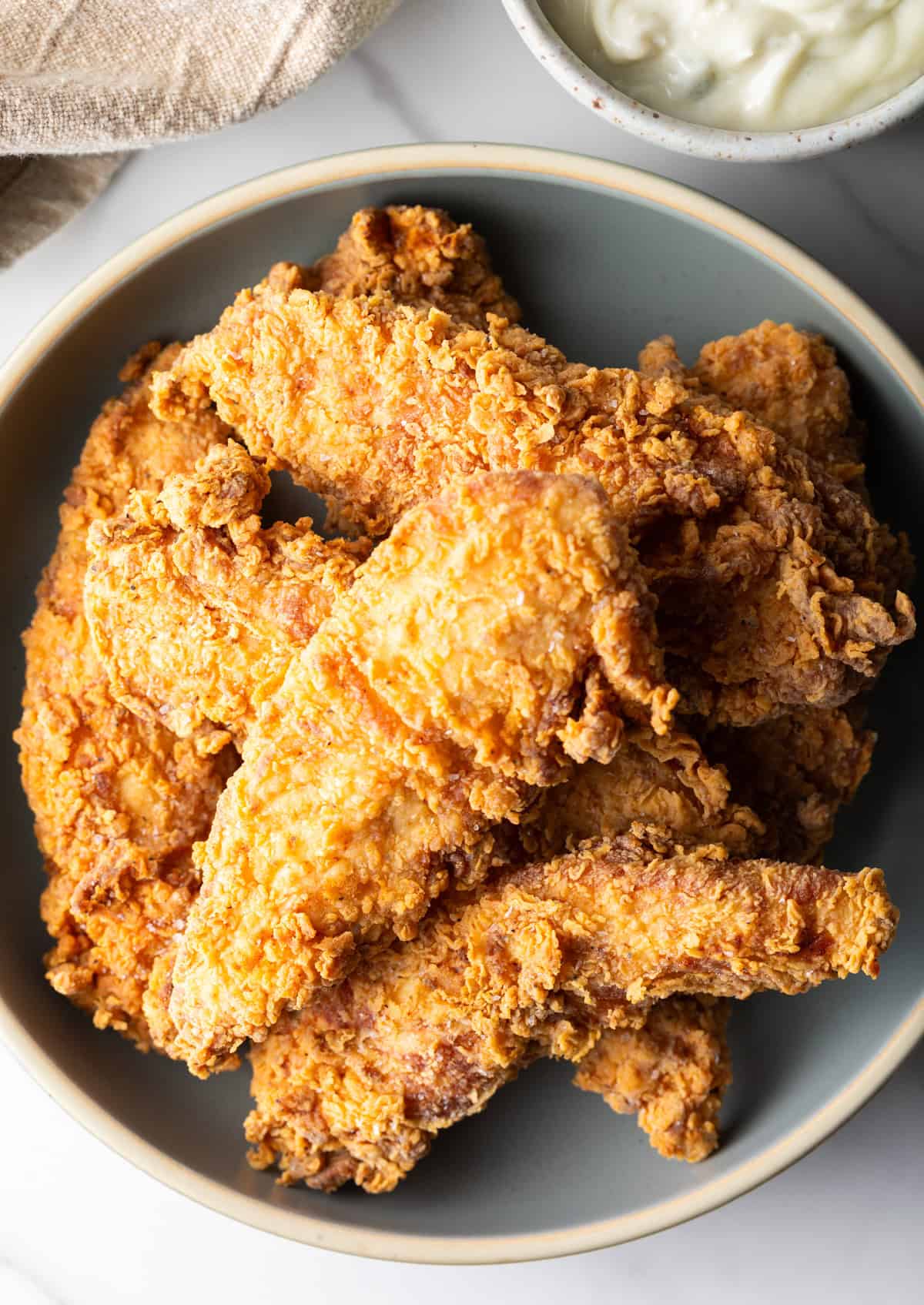 An overhead shot of a bowl filled with a deep fried chicken tenders recipe.
