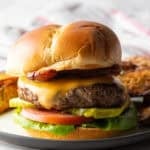 A juicy deer burger recipe featuring a deer burger patty between two buns and topped with cheese and condiments.