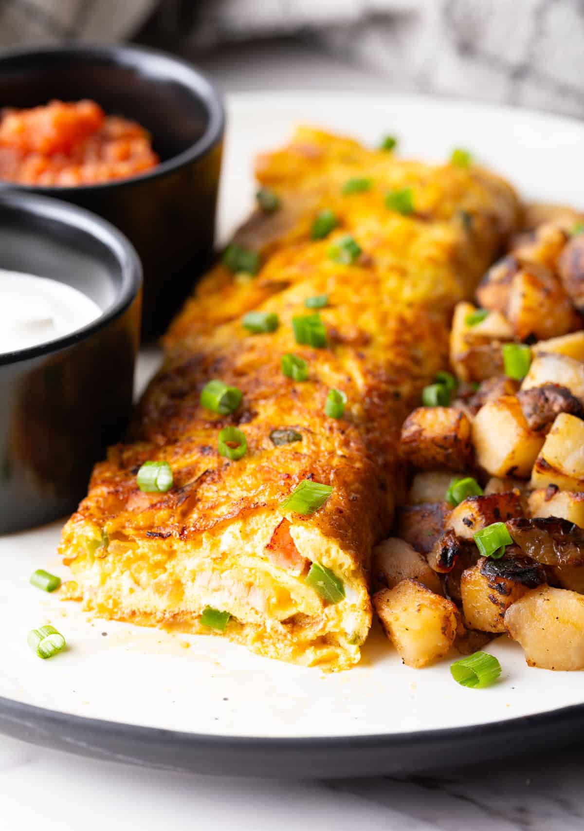 A Denver omelette with a slice taken out, showing you the inside of the omelette.