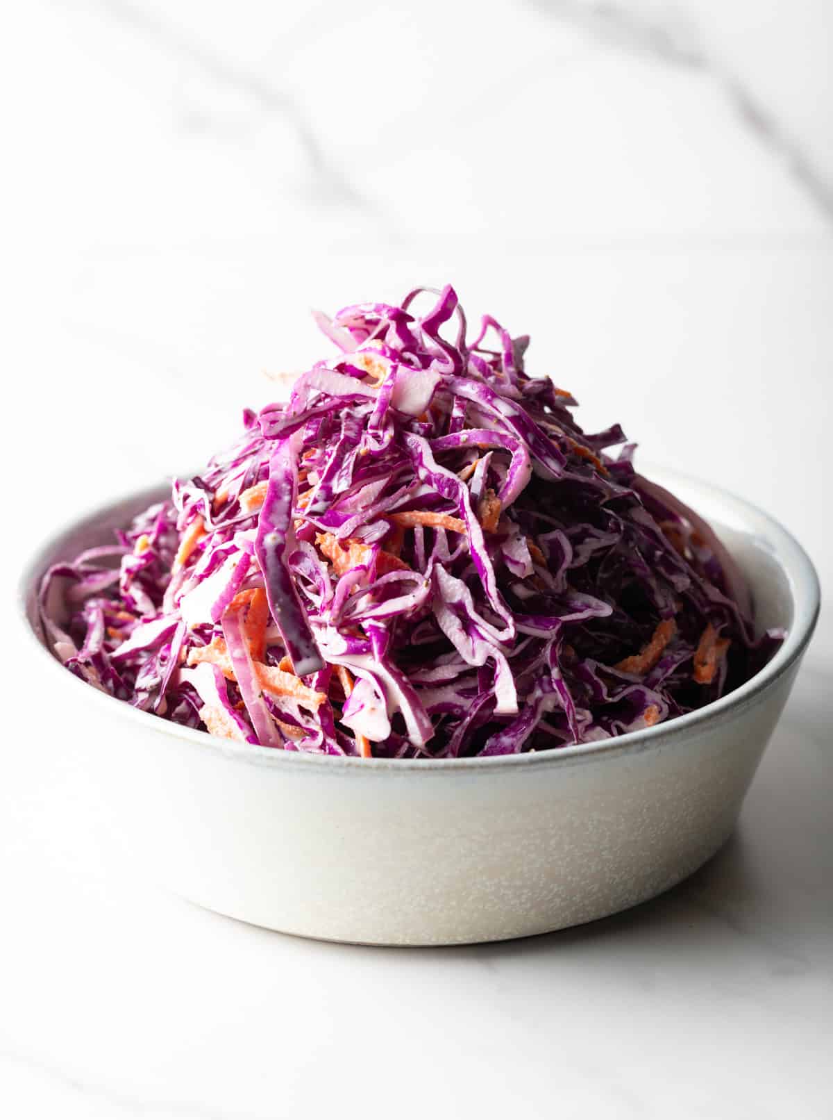 A white bowl filled with a red cabbage slaw recipe.