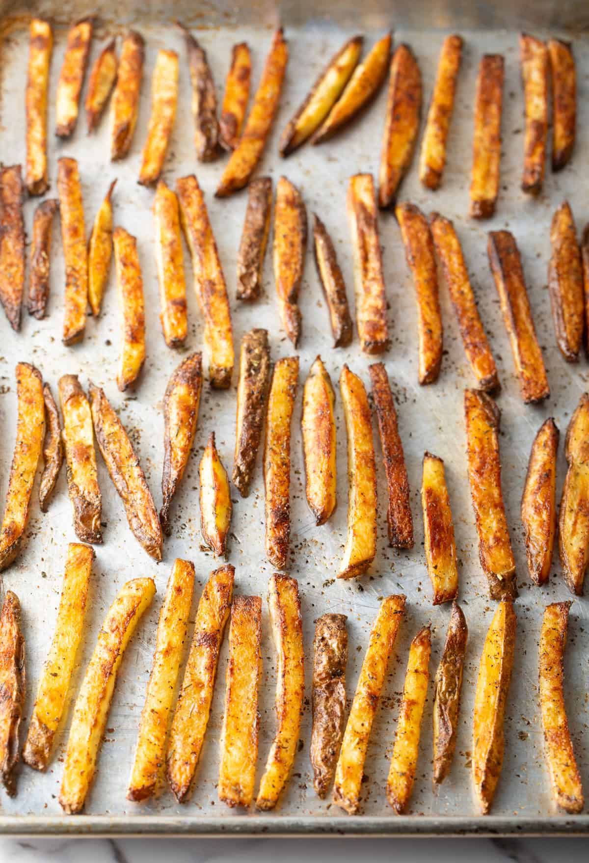 Crispy oven baked French fries on a baking sheet.