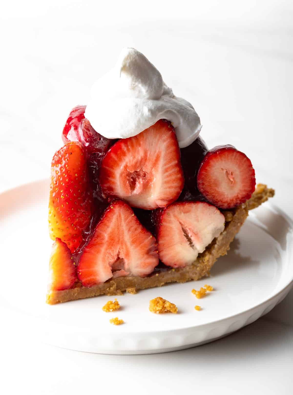 A slice of easy strawberry pie with whipped cream on top.