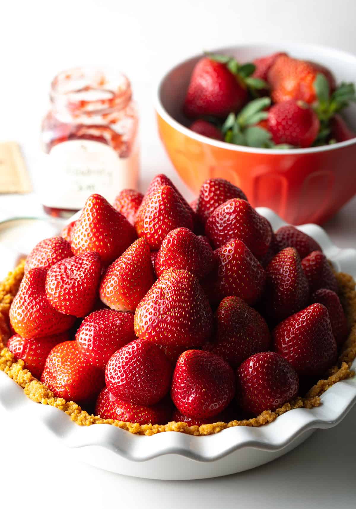 Fresh strawberries are stacked on a no bake strawberry pie crust.