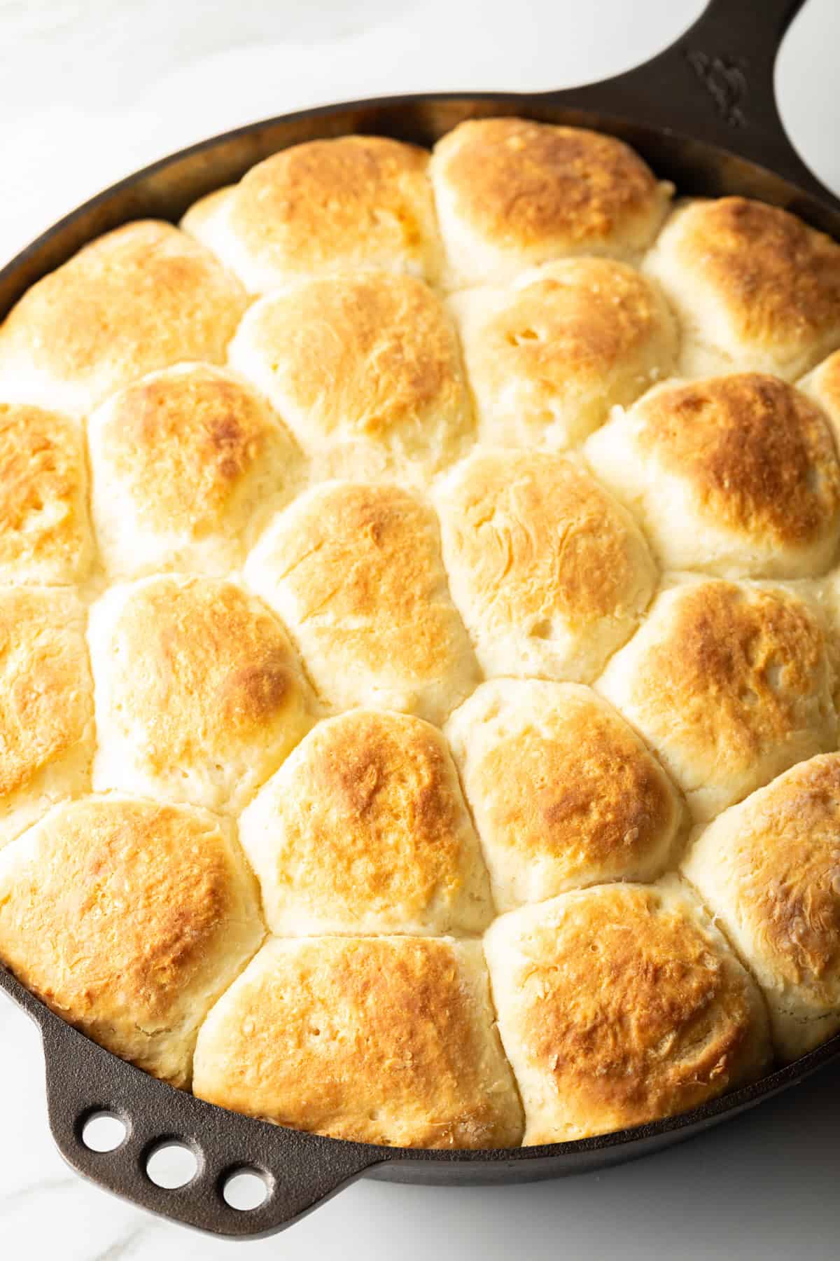 Freshly baked angel biscuits in a black skillet.