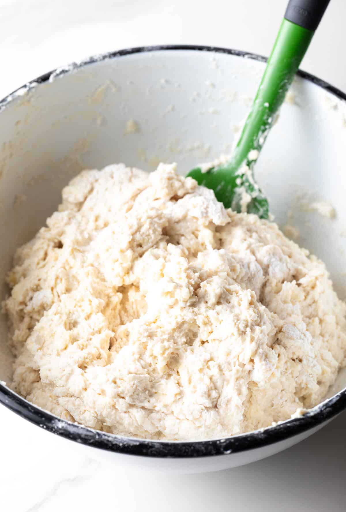 A white bowl filled with a homemade yeast biscuit mixture.