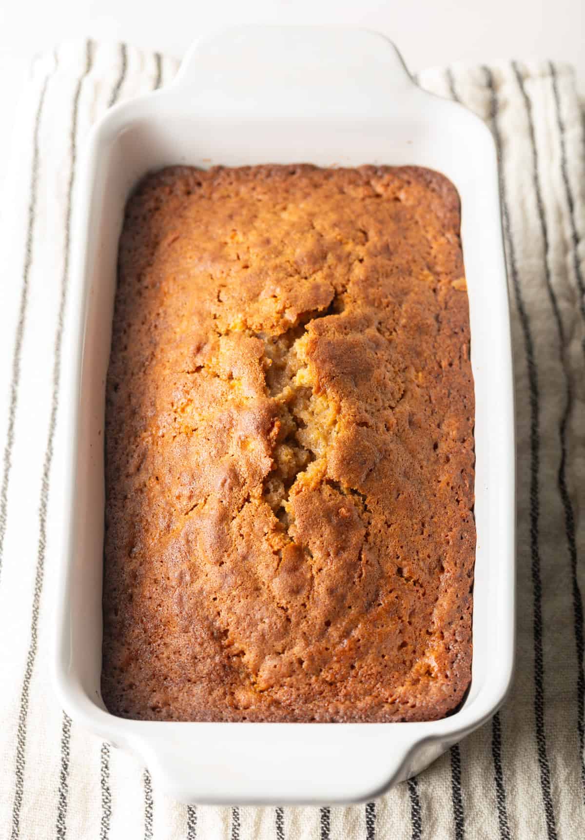 Freshly baked apple bread in a white baking dish.