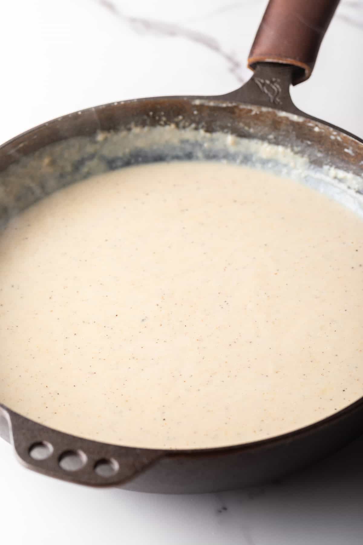 A homemade gravy with bacon grease in a black skillet.