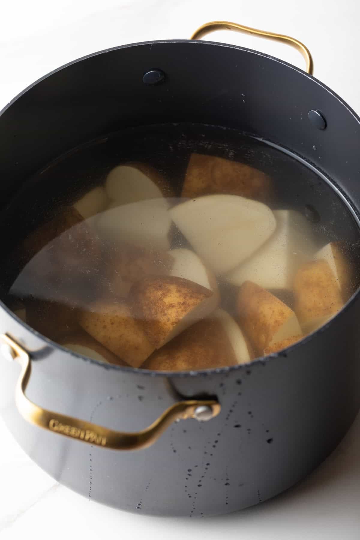 Potato pieces are in a pot of water, ready for boiling.