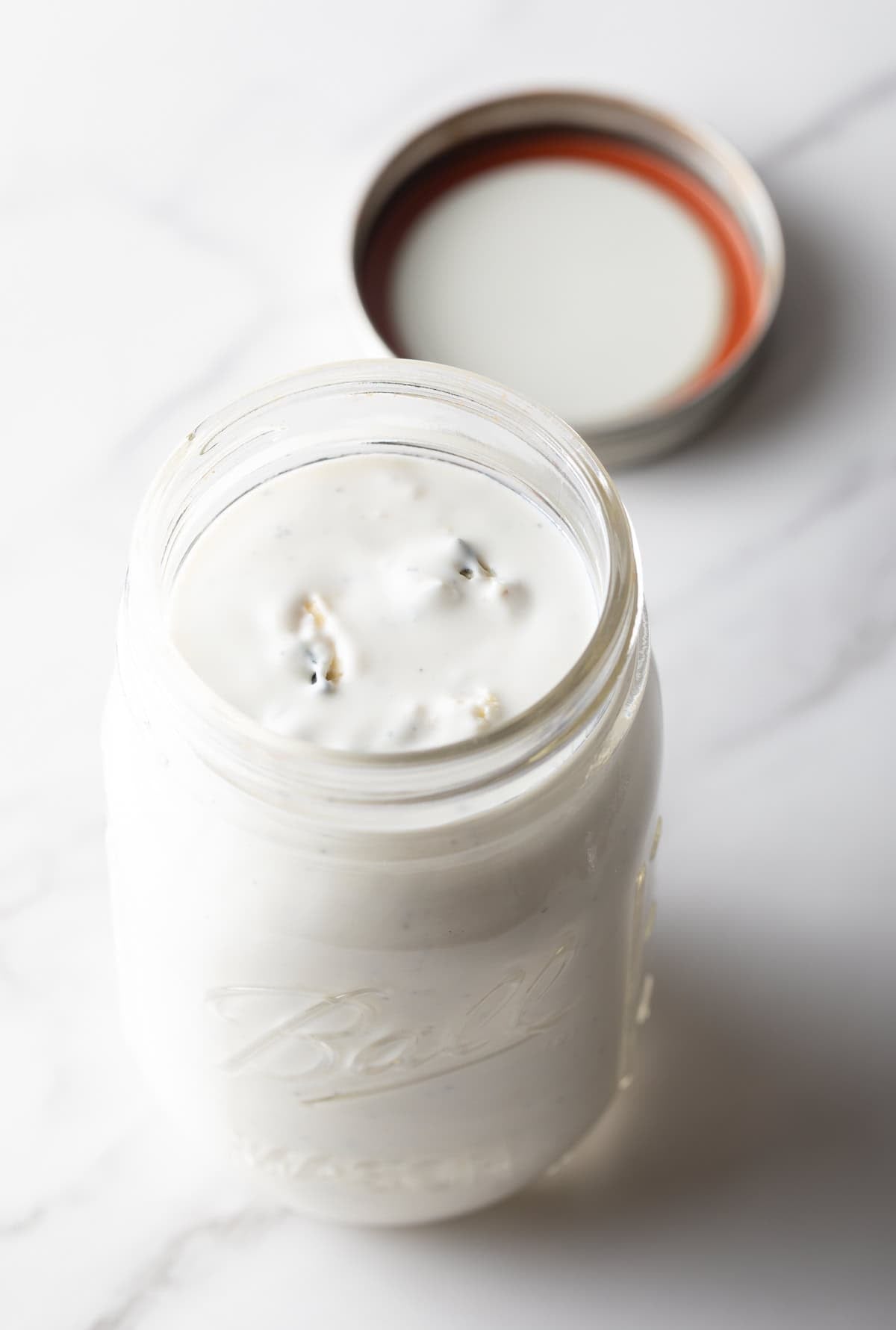 A glass jar filled with the a homemade blue cheese dressing recipe.