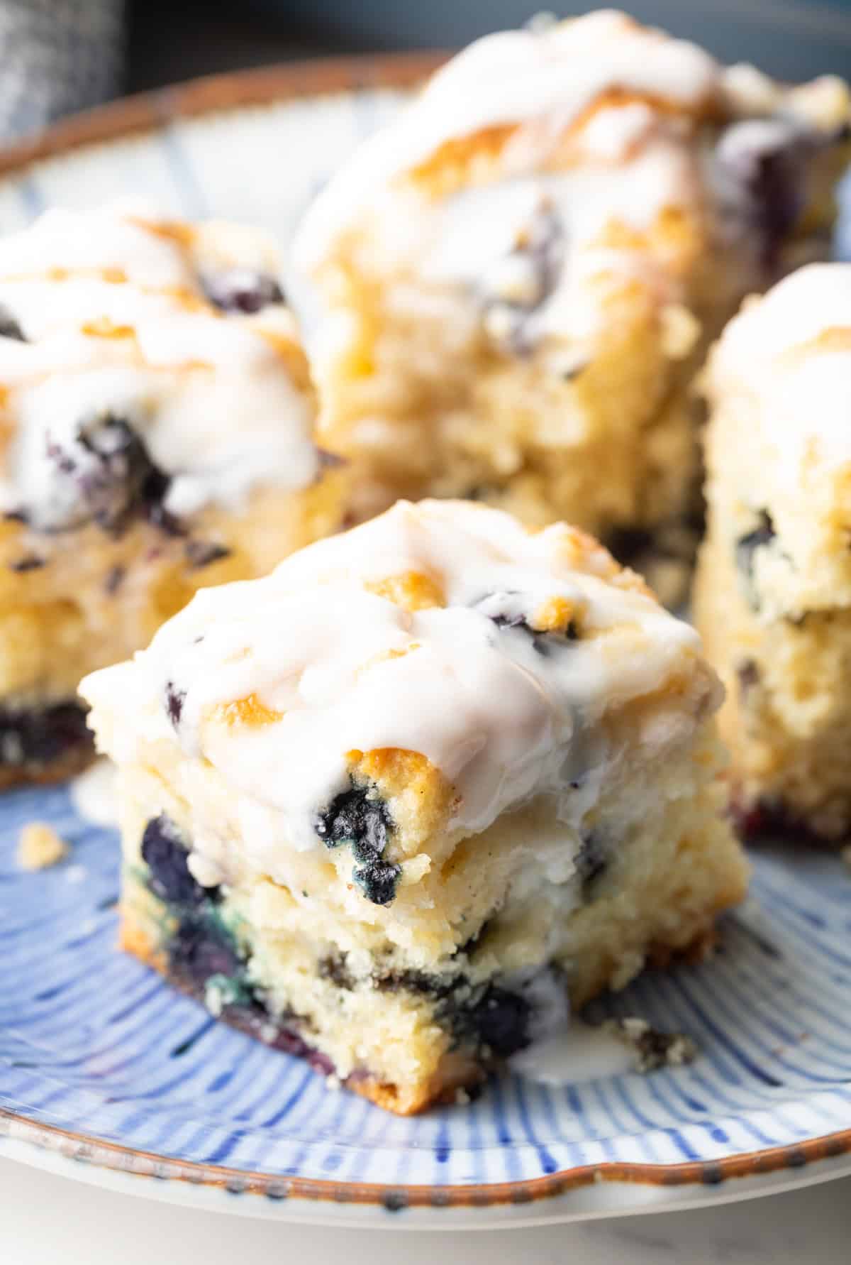 A closeup shot of a fluffy blueberry biscuit sitting on a blue plate.
