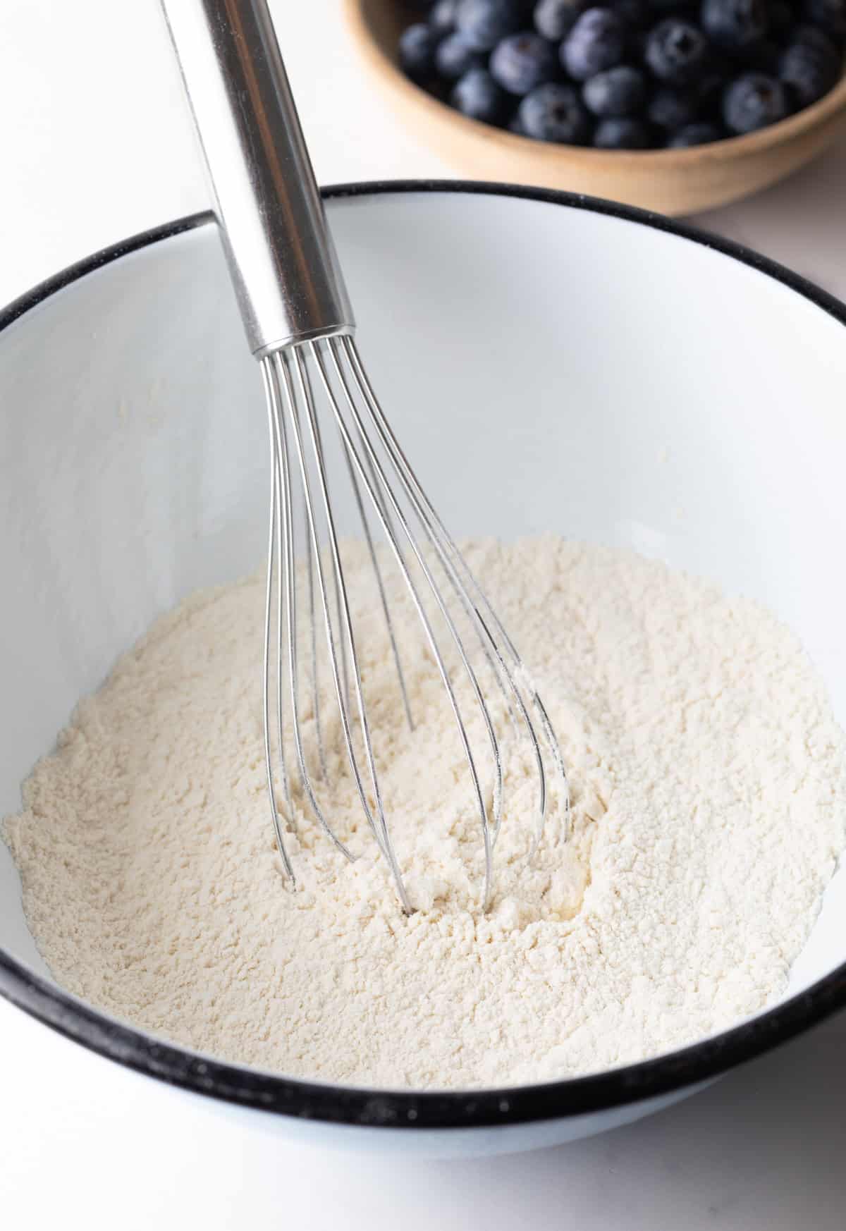 white bowl with dry ingredients and a whisk.
