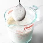ranch dressing recipe made in a pyrex pitcher with spoonful of thick dressing