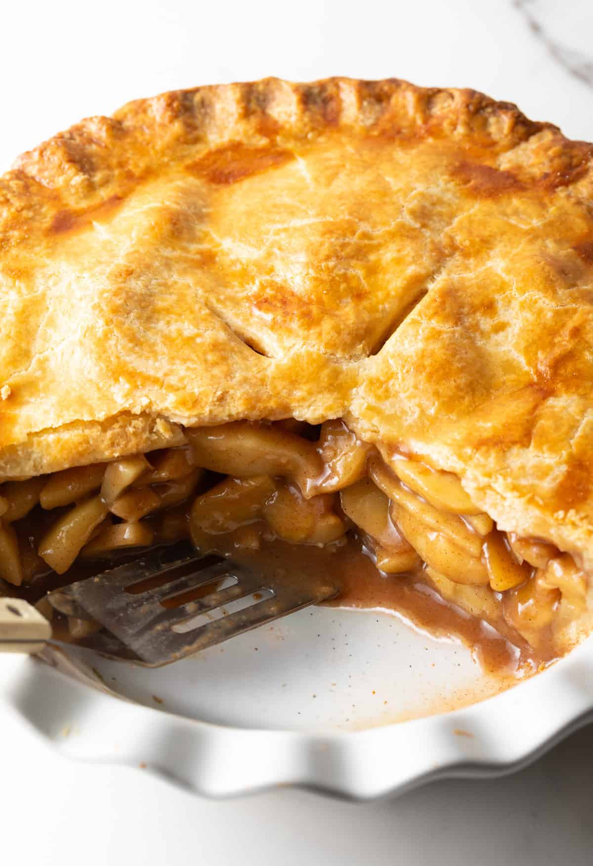 A whole apple pie with slices taken out, showing a cross-section of the pie.