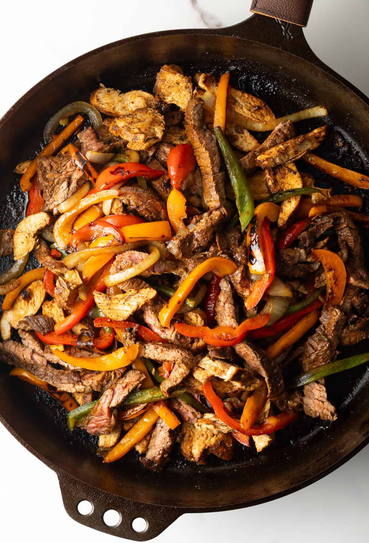 An easy steak fajita recipe in a black skillet, with a homemade fajita marinade.