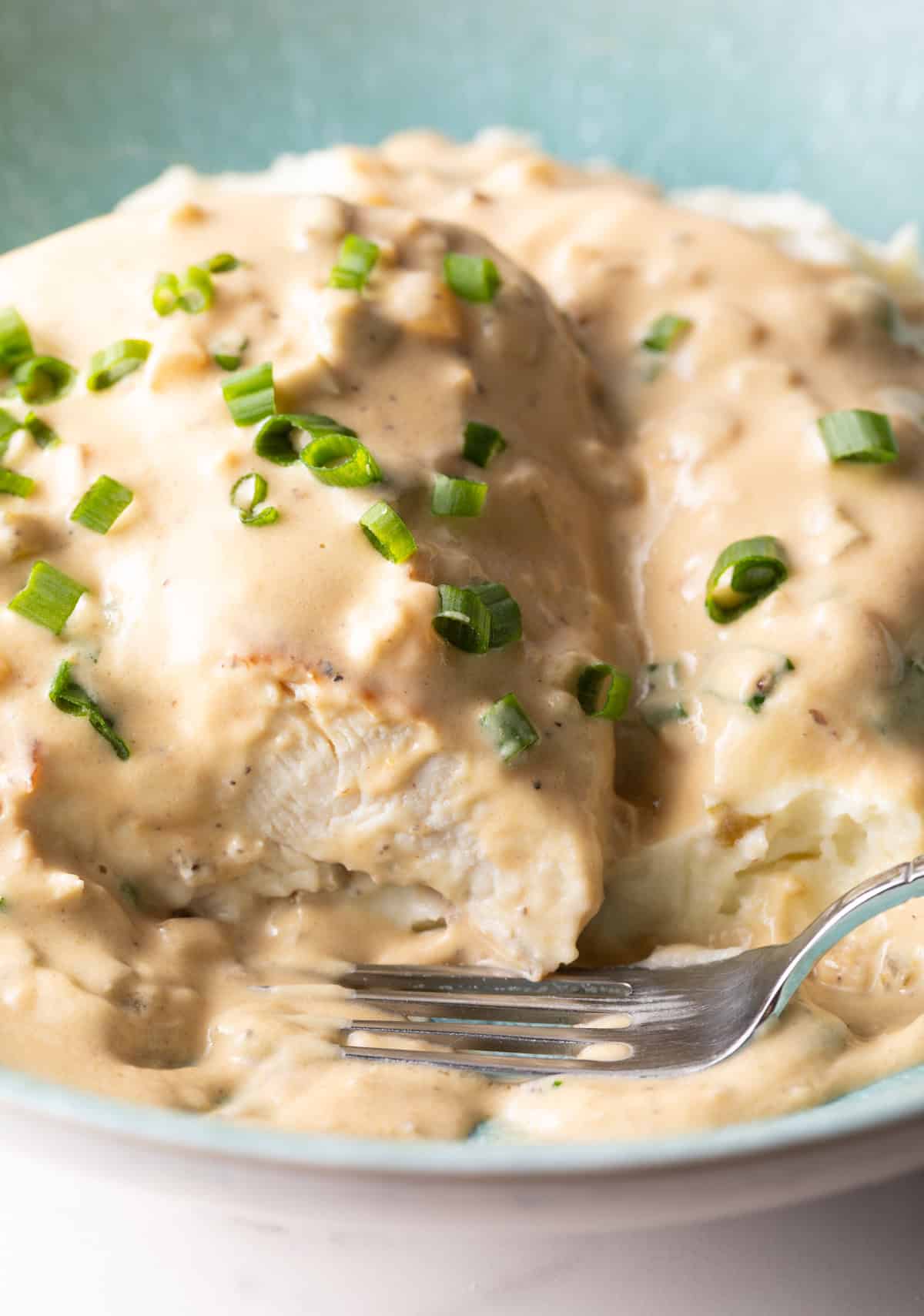 A plate of jalapeno popper chicken with a bite taken out and a fork laying on the plate.