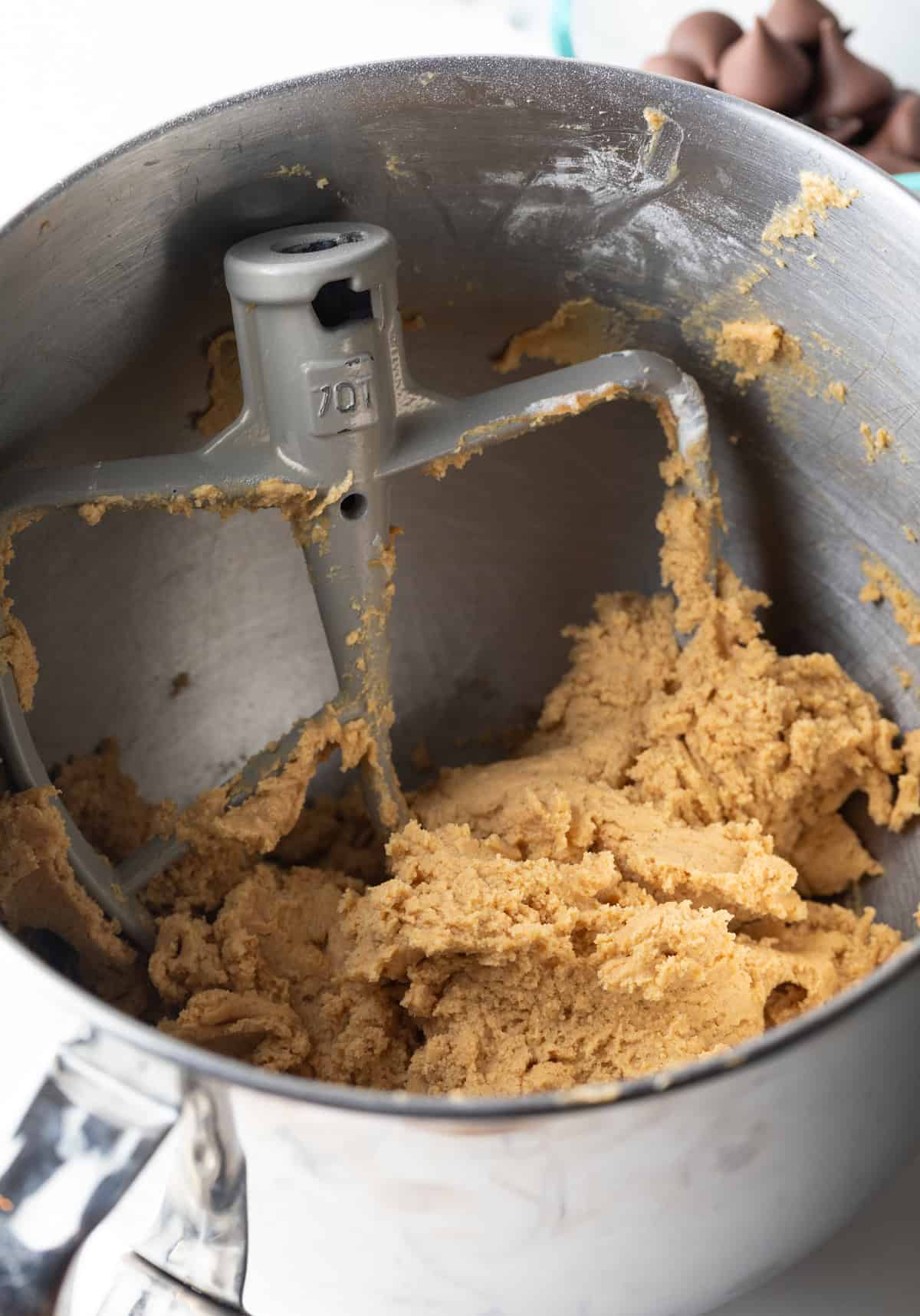 Peanut butter blossom cookie recipe ingredients in a stand mixer having just been mixed.