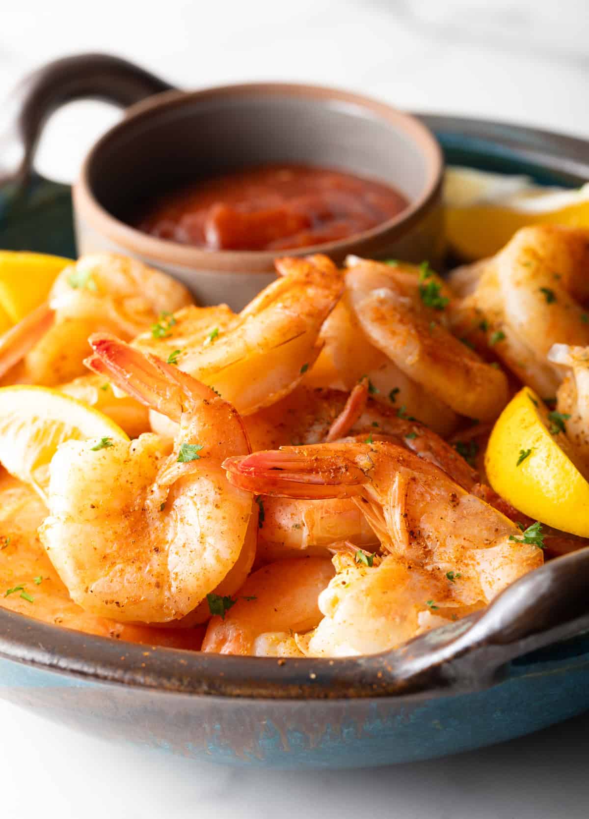 A close-up shot of peel-and-eat shrimp ready to be peeled and dipped in cocktail sauce.