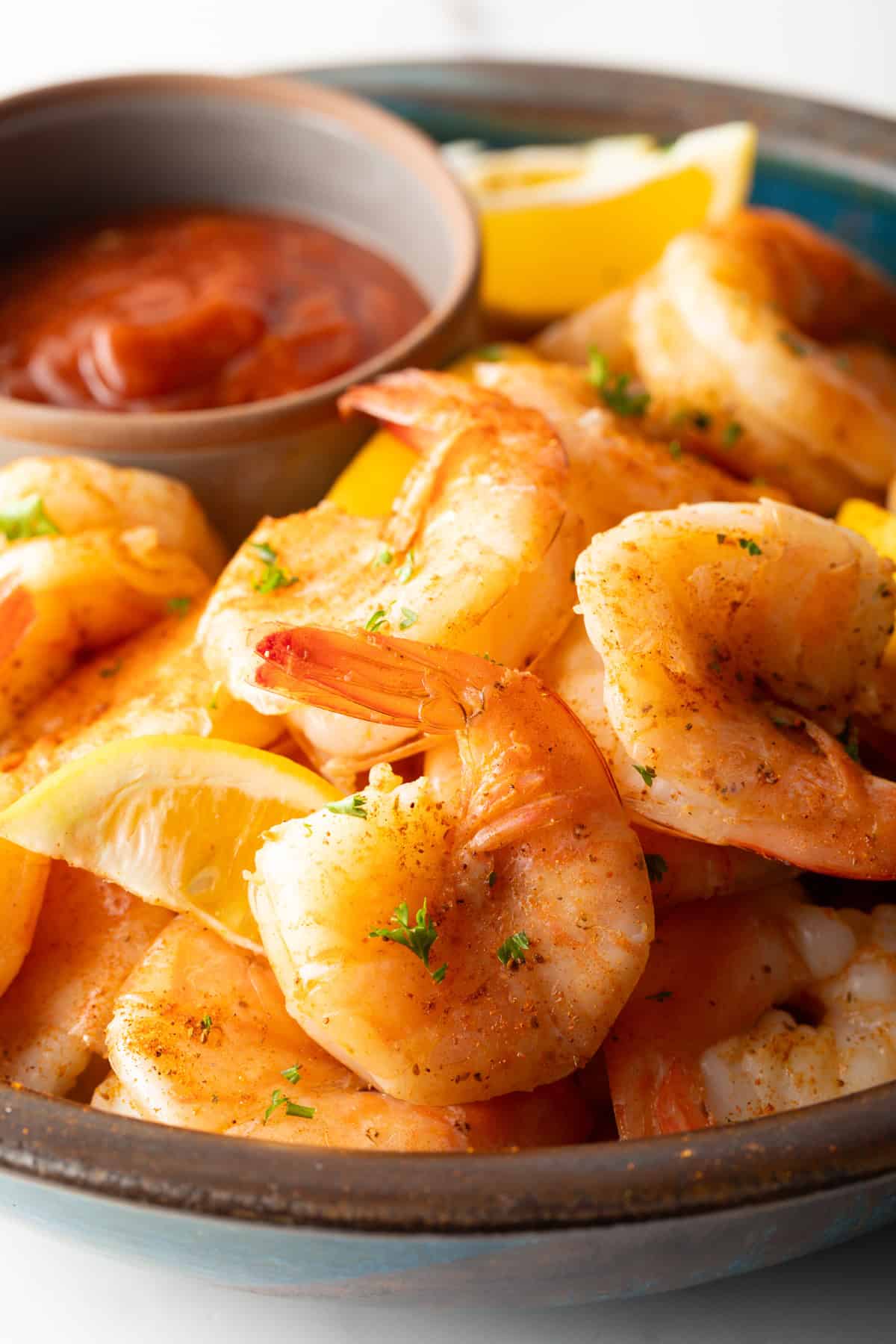A close-up shot of shrimp ready to be peeled and dipped in cocktail sauce.