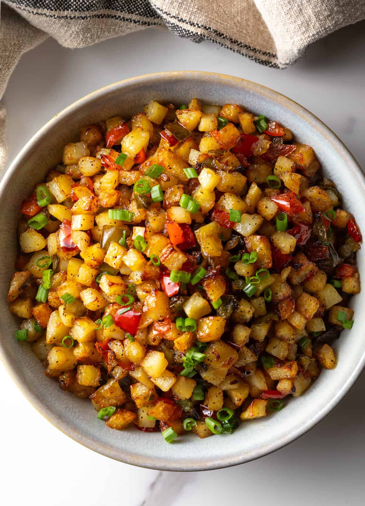 An overhead shot of a bowl of roasted obrien potatoes.