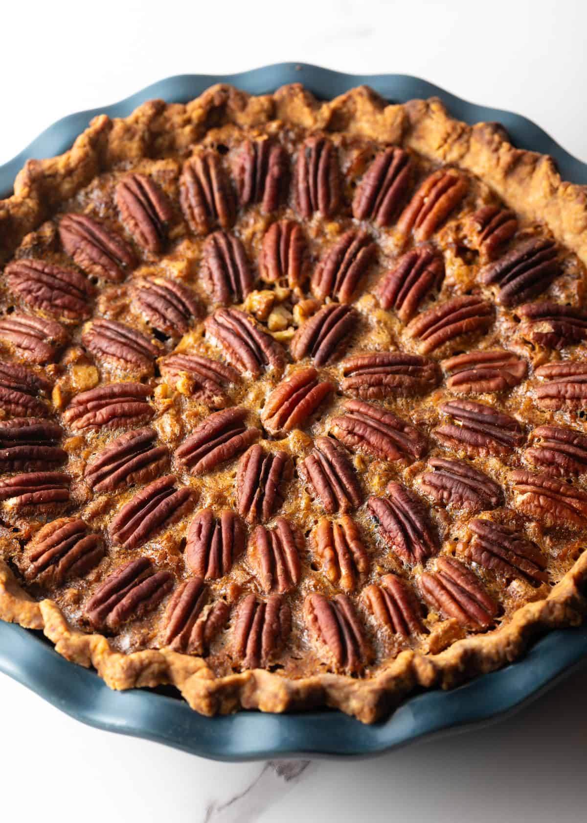 A simple pecan pie recipe sitting in a blue pie plate.