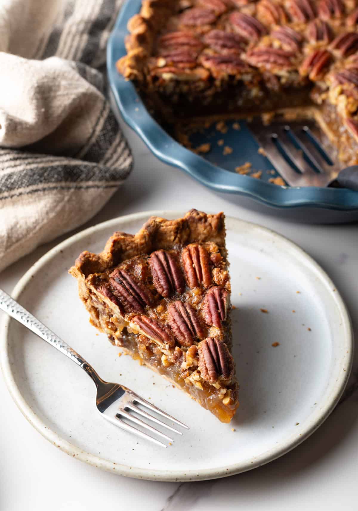 A slice of pecan pie on a plate with fork.