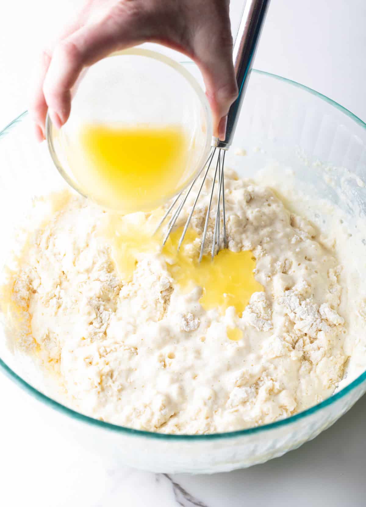 adding melted butter to the pancake mix