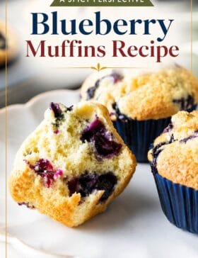 Single-image poster of golden-topped blueberry muffins stacked on a rustic surface, styled in warm gold, deep red, teal, and olive tones.