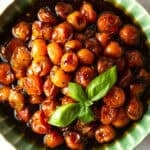 roasted cherry tomatoes in green bowl with basil