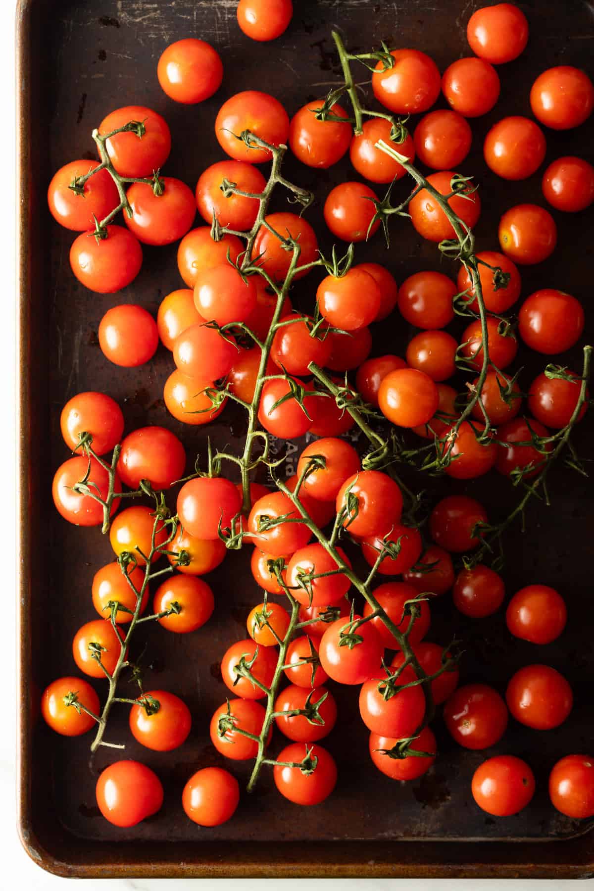 fresh cherry tomatoes on baking sheet