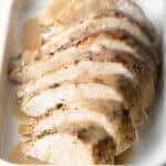 A sliced slow cooker turkey breast sitting in a crock pot.