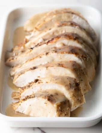 A sliced slow cooker turkey breast sitting in a crock pot.